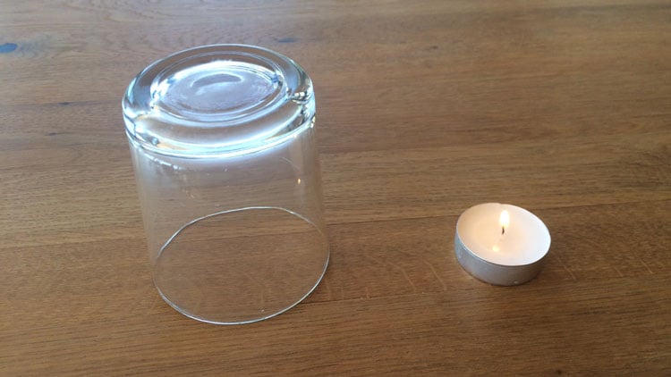 Teelicht neben einem Glas