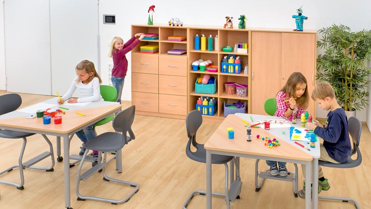 Schüler sitzen an dreieckigen Tischen