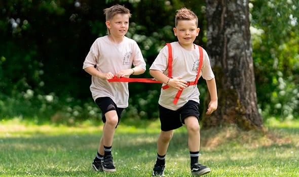 Platz zum Spielen Zwei Jungs spielen mit Pferdegeschirr